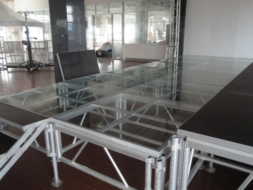 Une scène en praticables de verre et d'aluminium, montée dans une salle