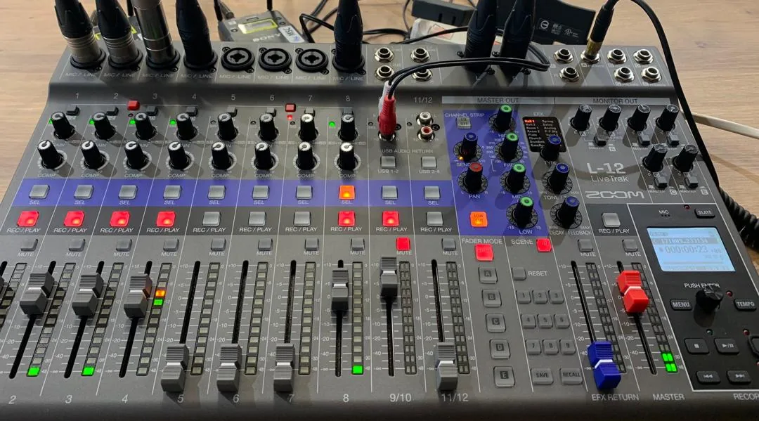 Une table de mixage numérique, micros branchés, en régie